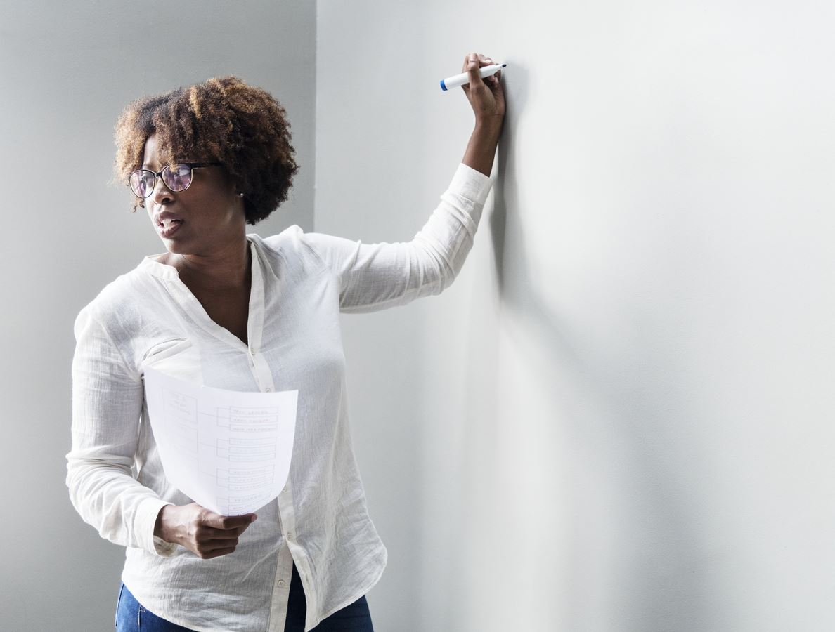 Picture of Black female teacher writing on a white board
